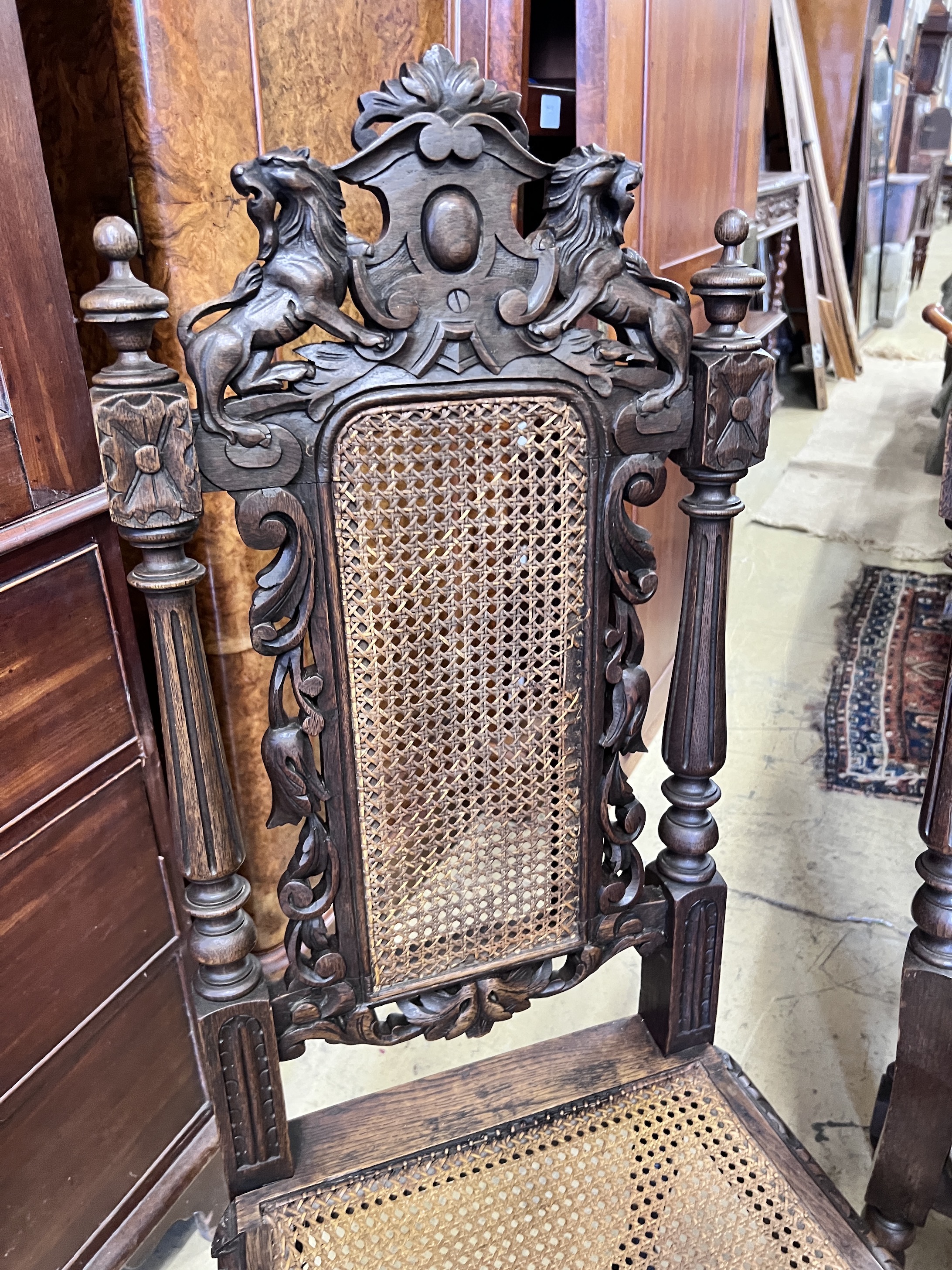 A set of four late 19th century Flemish style carved oak dining chairs with caned seats